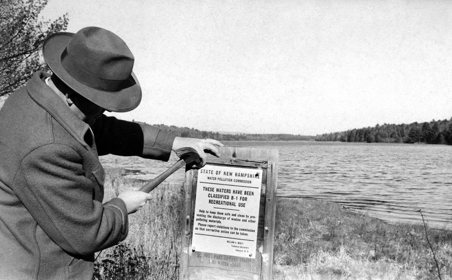 Man in a hat posting water-classification notice