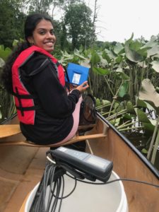 TIDES student in a canoe holding a pH kit