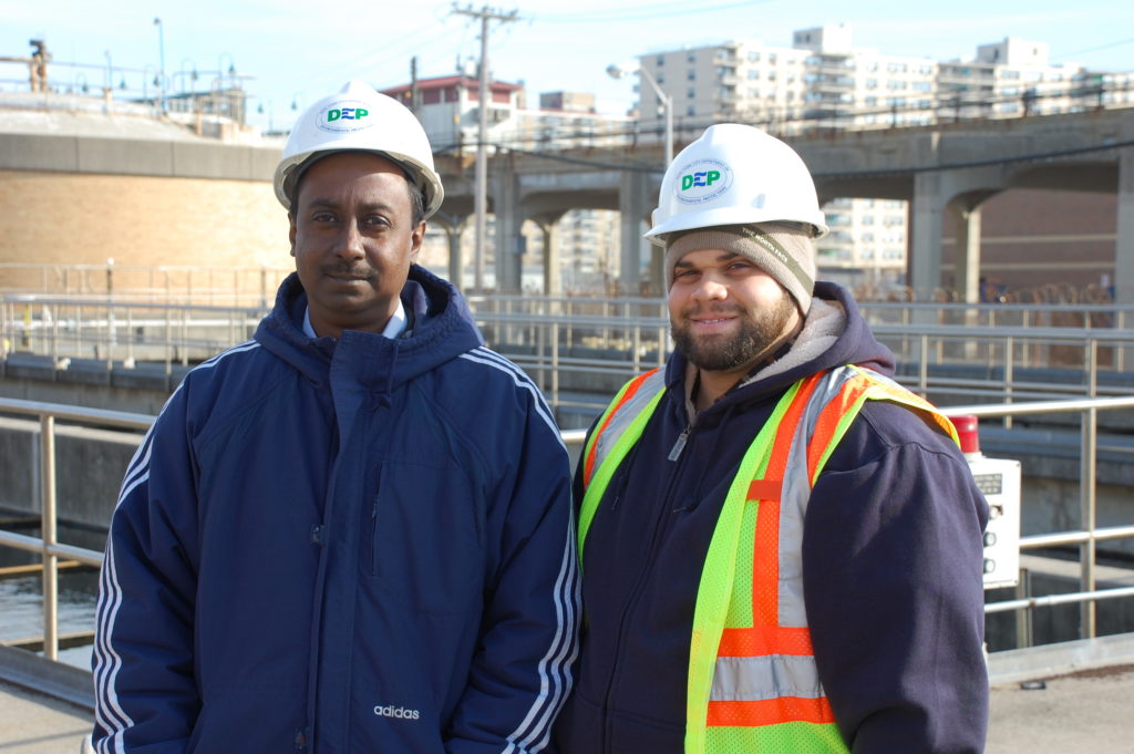 Two wastewater operators at a treatment plant.