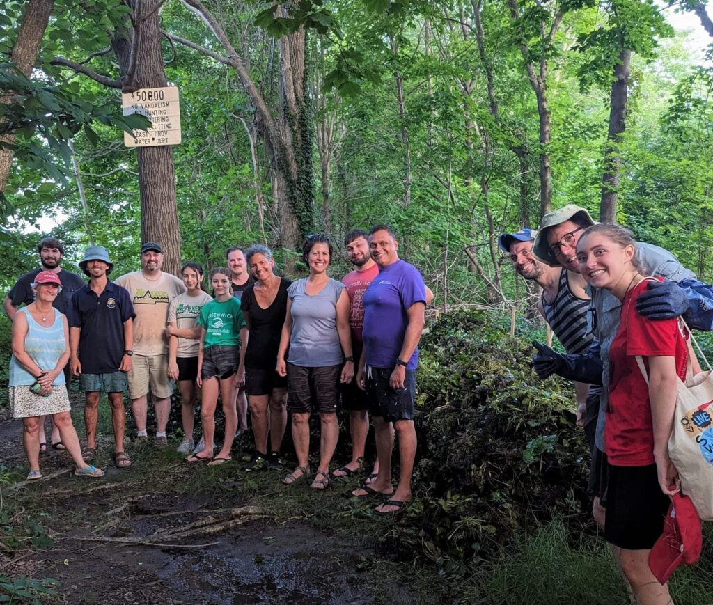Group of people standing next to a large pile of water chestnut.