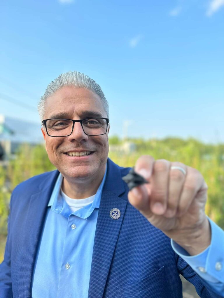Mayor of East Providence (Rhode Island) Robert (Bob) DaSilva holding the spiky nut, or seed, of a water chestnut.