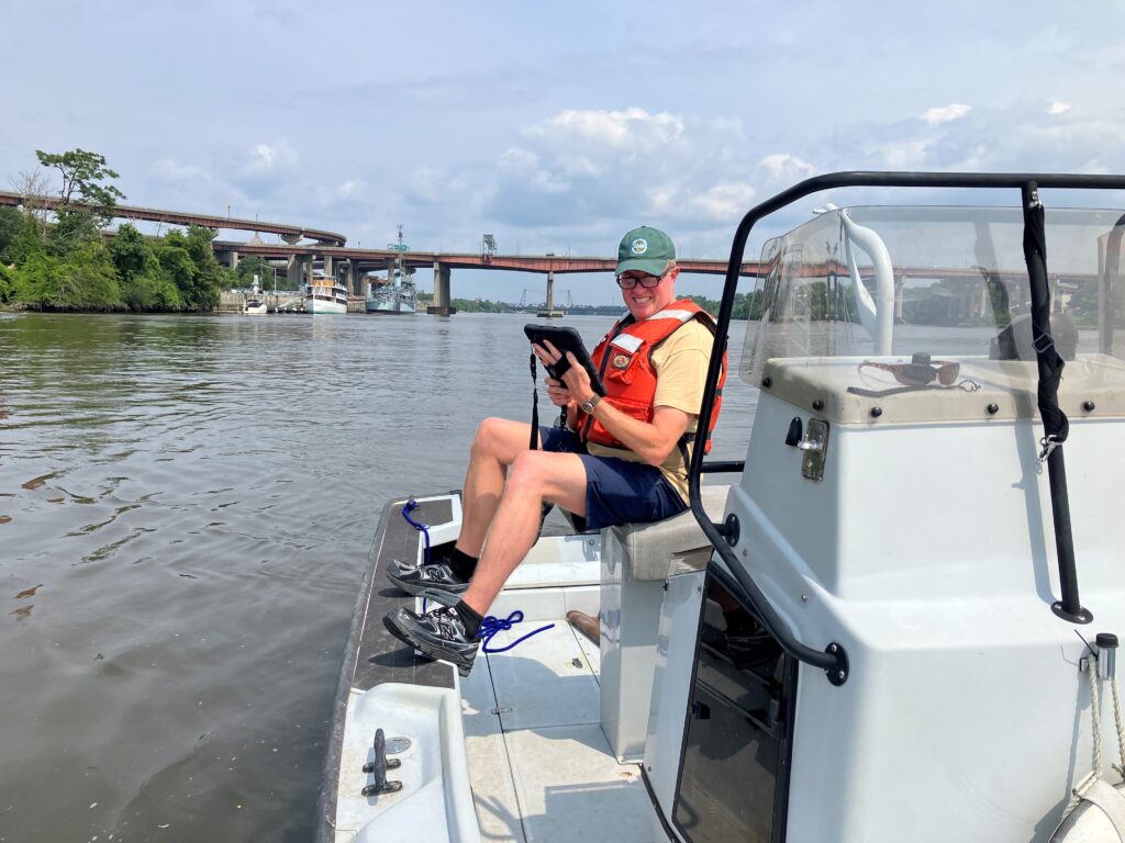 Chris Bowser recording data on a boat in the Hudson River.