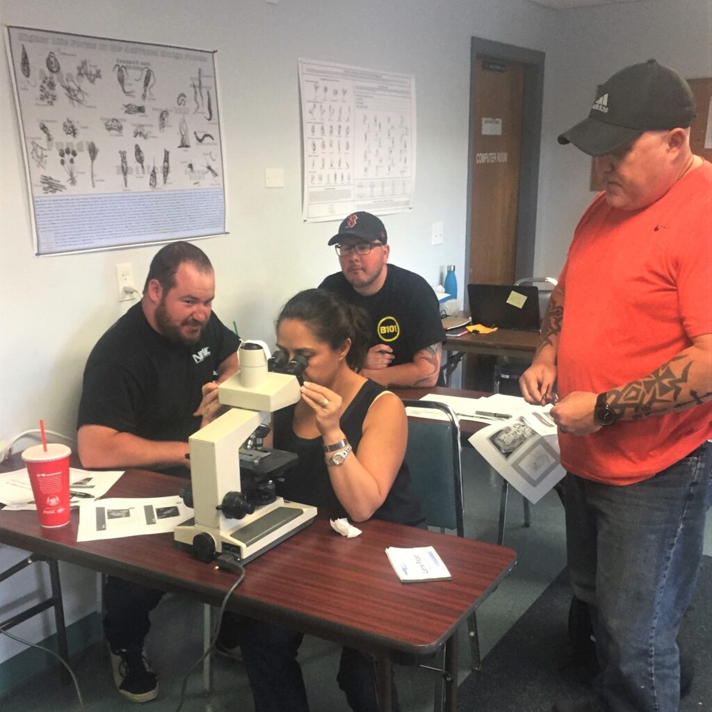 Wastewater training using a microscope with trainer Nora Lough.