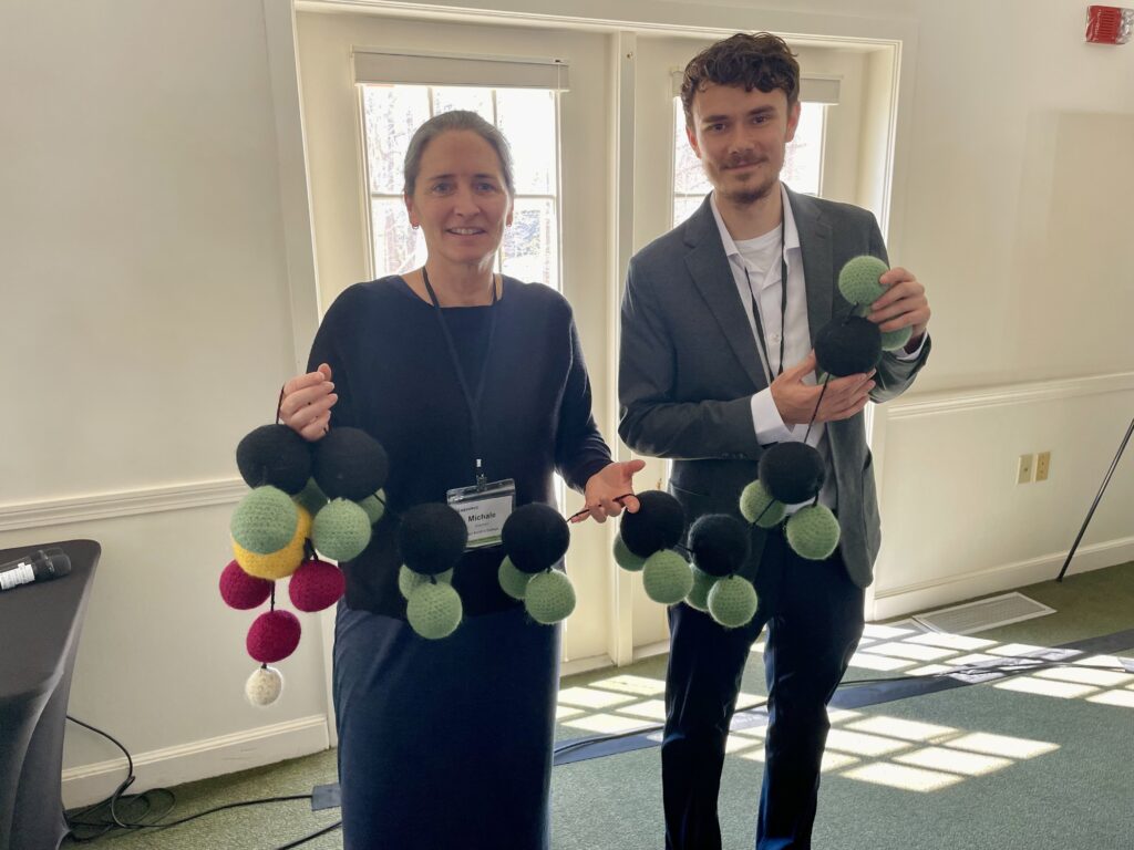 Michale Glennon, senior research scientist at Paul Smith's College Adirondack Watershed Institute, displays a wool-crafted PFAS molecule as part of the Wool and Water project, alongside NEIWPCC Environmental Analyst Devon Case.