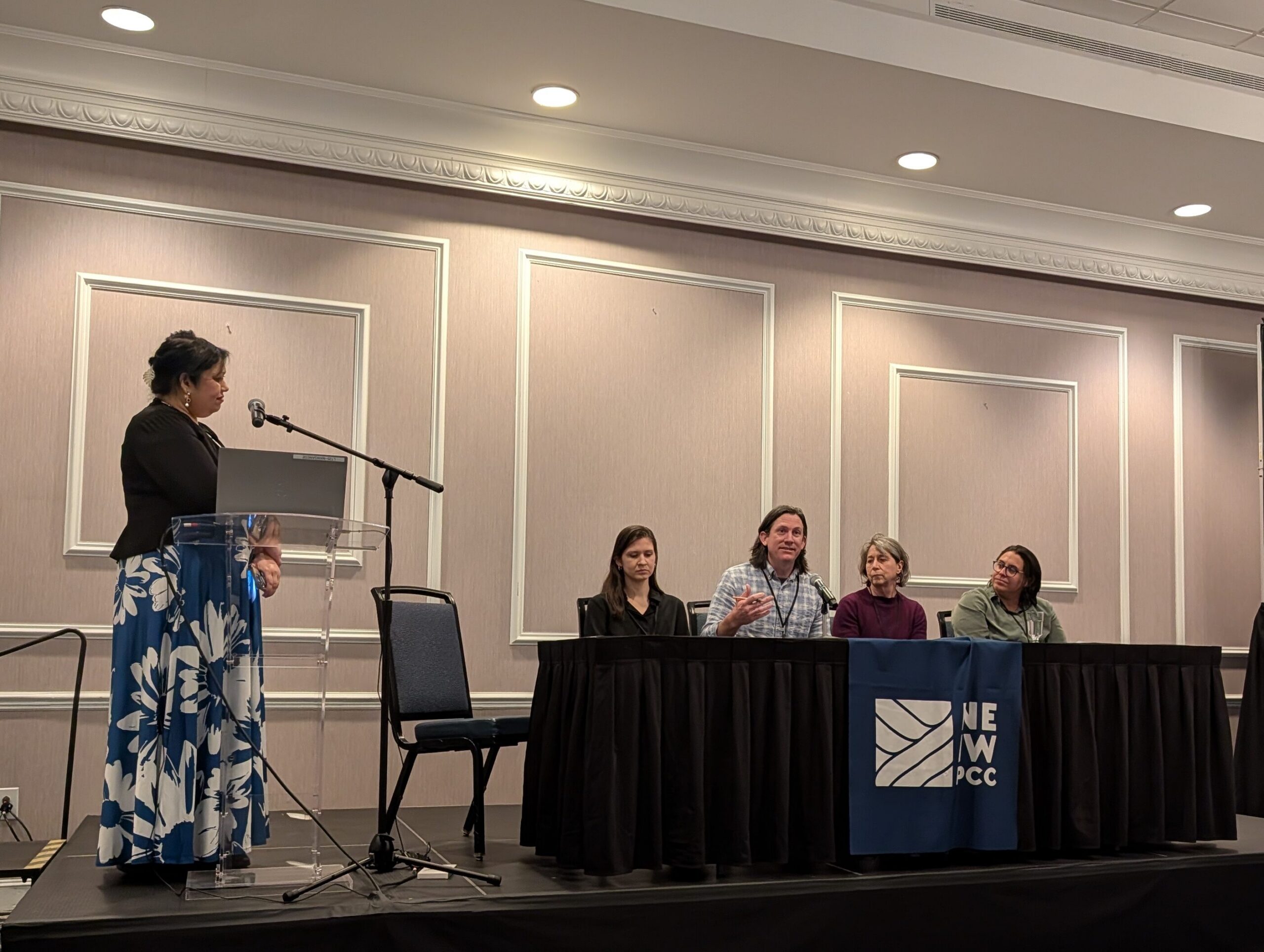 A moderator asks questions to a panel of four