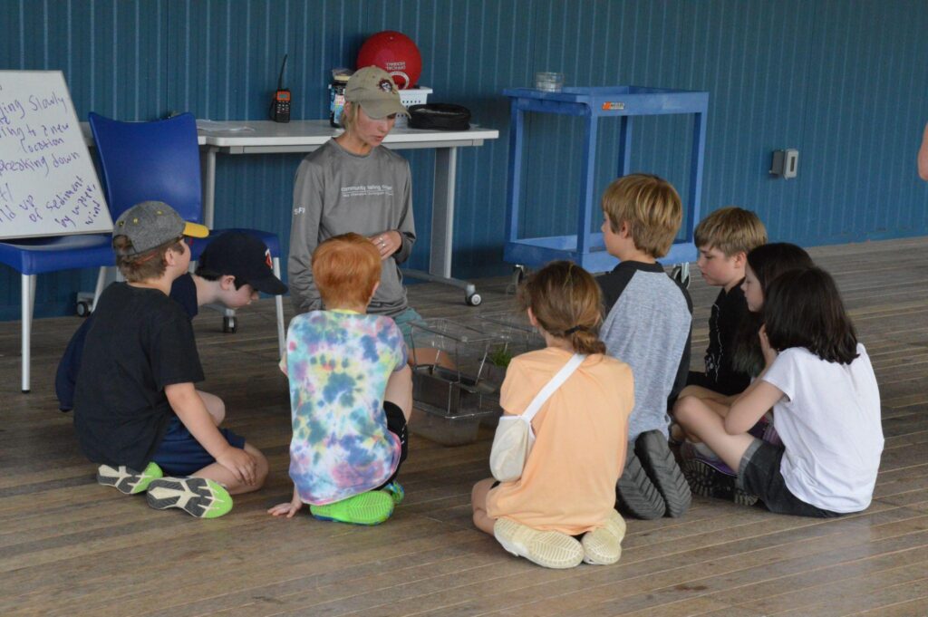 A Community Sailing Center educator provides a lesson to a group of youth.